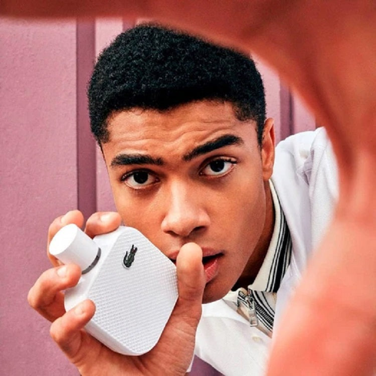 Person holding a white electronic device with a pink background