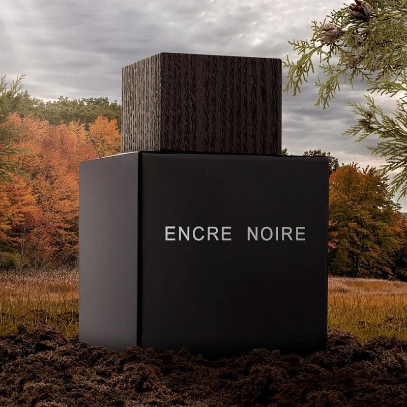 Encre Noire perfume bottle with a forest background
