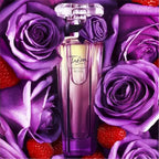 Perfume bottle surrounded by purple roses and red berries