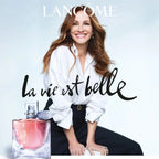 Lancème advertisement with a woman and a perfume bottle on a light blue background.