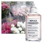 Maison Margiela perfume bottle with a bouquet of flowers in the background