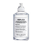A spray bottle of Maison Margiela Lazy Sunday Morning Eau de Toilette, with a white label and text detailing the fragrance description.