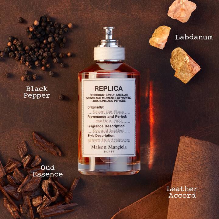 Bottle of 'Replica' with black pepper, labdanum, and oud essence on a brown background