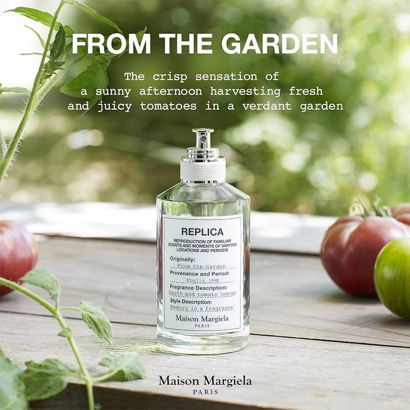 Maison Margiela perfume bottle with tomatoes and garden elements on a wooden surface