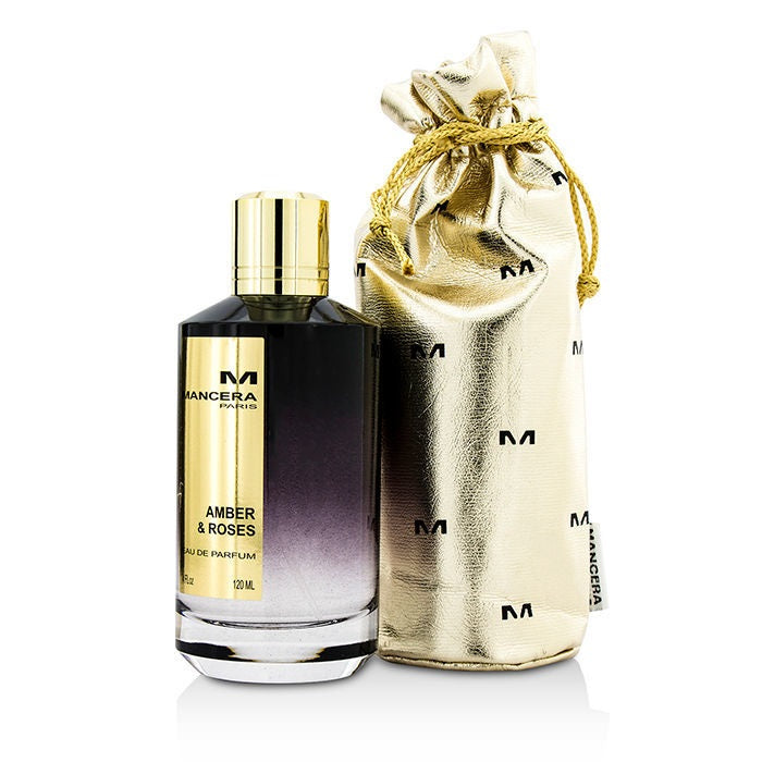 A bottle of Amber & Roses Eau de Parfum by Mancera, accompanied by a golden pouch, against a white background.