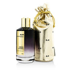 A bottle of Amber & Roses Eau de Parfum by Mancera, accompanied by a golden pouch, against a white background.
