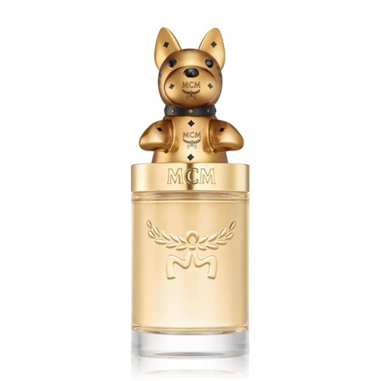 MCM Gold perfume bottle with a metallic gold dog-shaped cap and clear glass base on a white background.