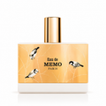 A rectangular perfume bottle with a metallic gold cap and a gold-toned label featuring black bird illustrations and the text 'Eau de MEMO PARIS'.