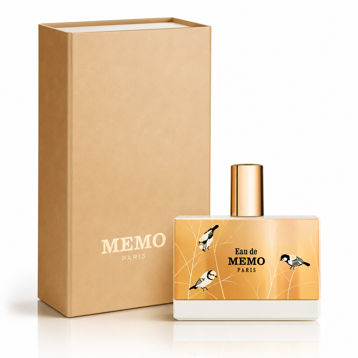 Memo Paris Eau de Memo Paris perfume bottle with a gold cap and gold label featuring bird illustrations, shown next to its brown kraft paper box on a white background.