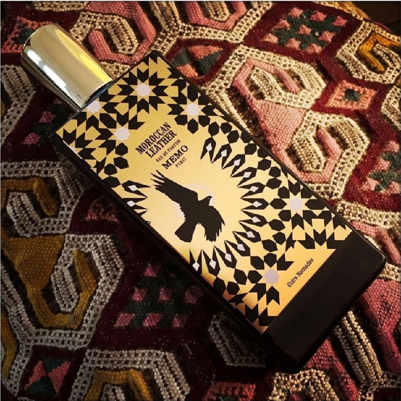 Perfume bottle with decorative label on a patterned fabric background