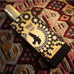 Perfume bottle with decorative label on a patterned fabric background