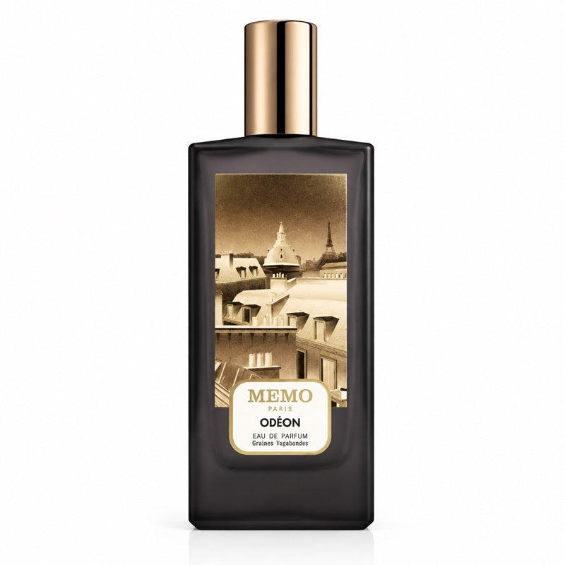 A rectangular dark glass perfume bottle with a metallic gold cap and a sepia-toned cityscape label reading MEMO PARIS ODÉON.