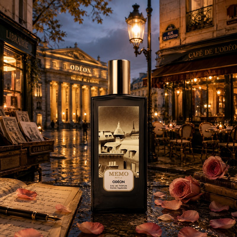 A perfume bottle labeled MEMO ODEON stands on a street in a Parisian-inspired evening scene with café tables, a lit lamppost, and scattered pink roses around it.