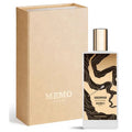 Perfume bottle with gold cap and black design next to a beige Memo Paris box on a white background