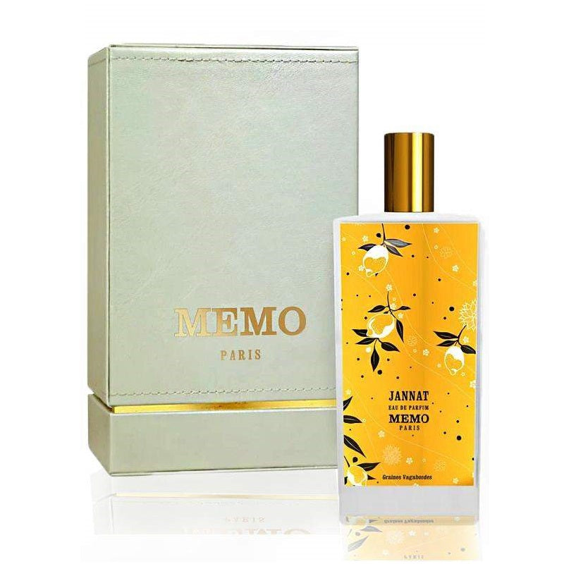 Memo Paris perfume bottle with yellow label and gold cap next to its packaging on a white background