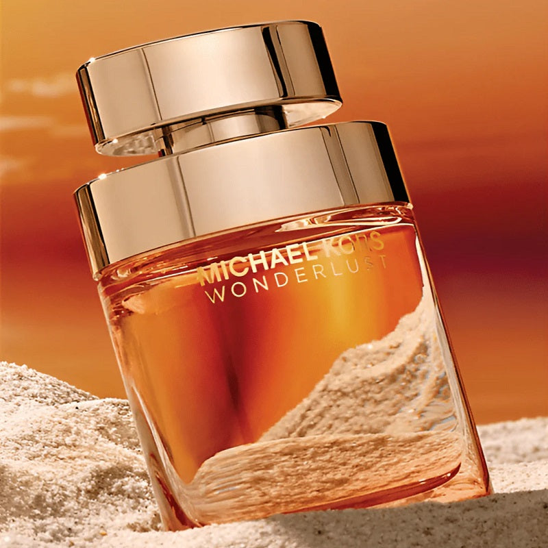 Perfume bottle labeled 'Wonderlust' by Michael Kors on a sand-like surface with an orange gradient background.
