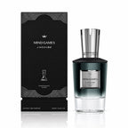A bottle of J'ADOUBE MIND GAMES fragrance with a dark gradient glass body and silver cap, displayed next to its black packaging box with silver geometric patterns.