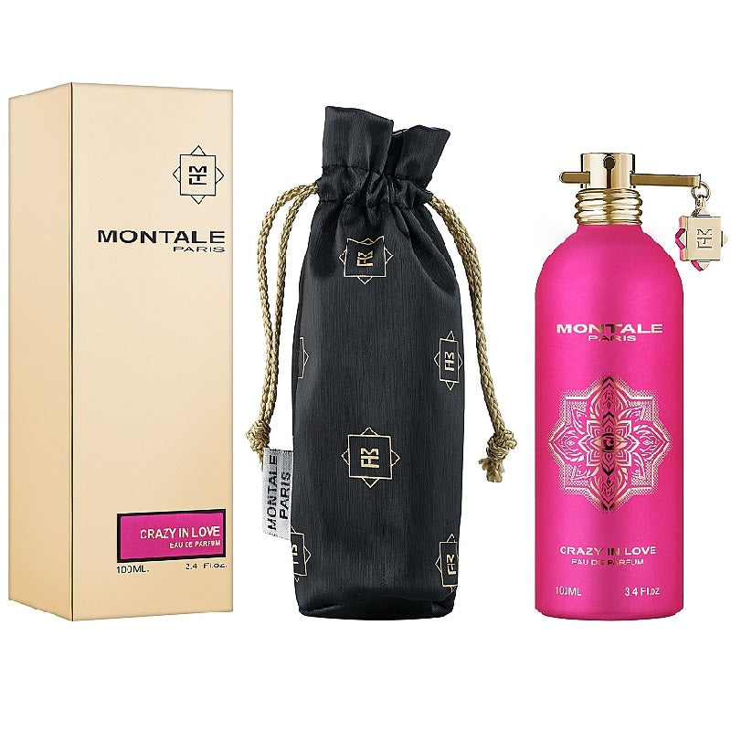 Pink perfume bottle with packaging and black drawstring bag on white background