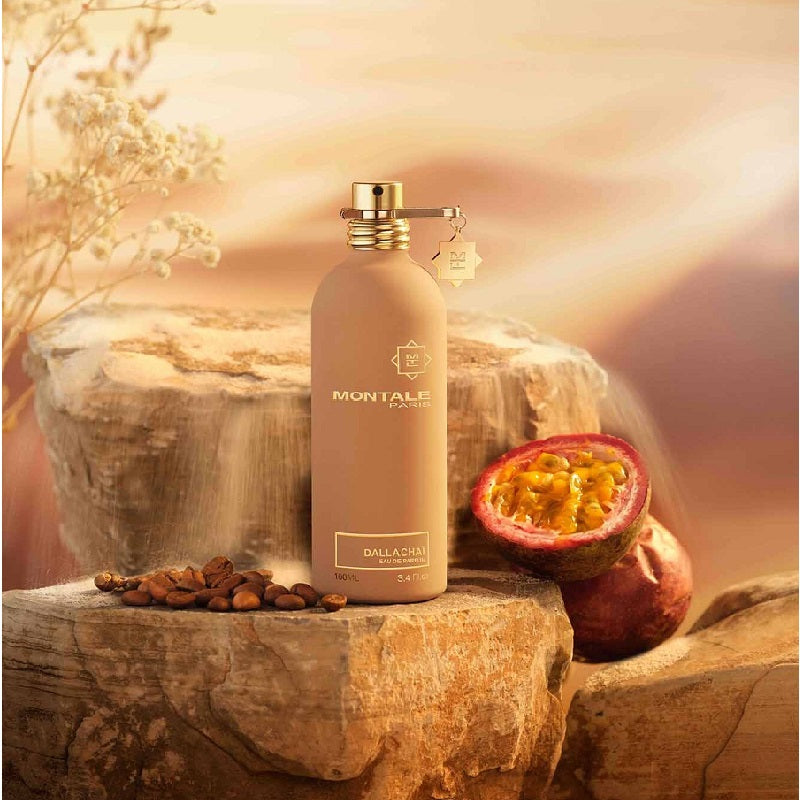 Montale perfume bottle with passion fruit and coffee beans on a stone surface