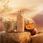 Montale perfume bottle with passion fruit and coffee beans on a stone surface