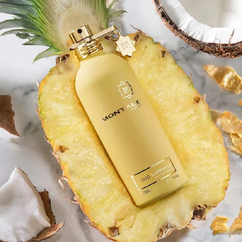 Montale perfume bottle on a pineapple slice with coconut pieces in the background