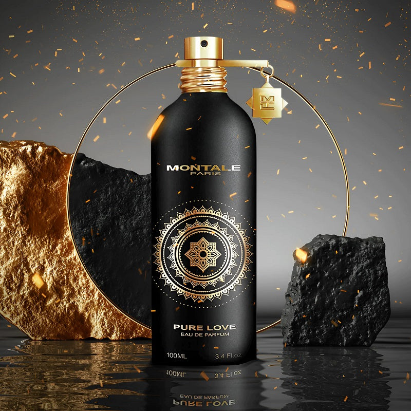 Montale Paris Pure Love Eau de Parfum bottle, 100ml, in matte black with a gold mandala design and gold cap, styled with gold and black rocks on a reflective dark surface.