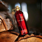 Red Montale perfume bottle on a wooden surface with a blurred background