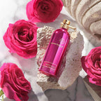 Montale Roses Musk perfume bottle surrounded by pink roses on a textured surface