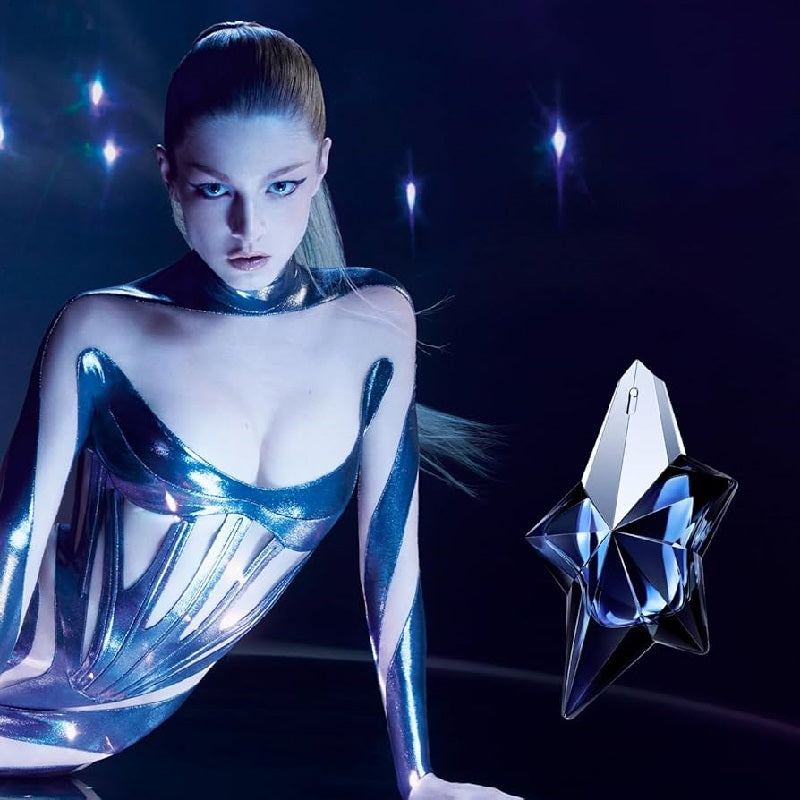 Woman in silver outfit with a metallic object against a dark background