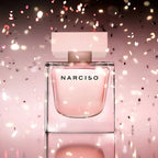 Perfume bottle with pink confetti on a soft pink background