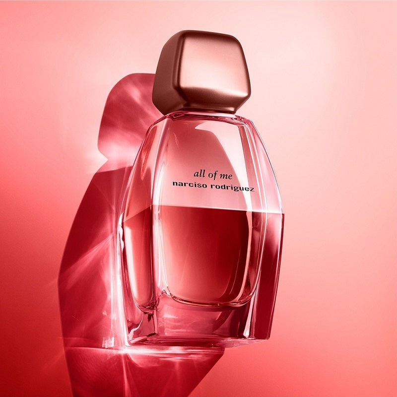 Perfume bottle labeled 'all of me' by Narciso Rodriguez on a pink background