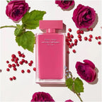 Pink perfume bottle with roses and berries on a white background