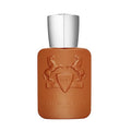 A bottle of Althaír Eau de Parfum by Parfums De Marly with a brown tinted glass and a silver cap, featuring an embossed design of a horse and a shield.