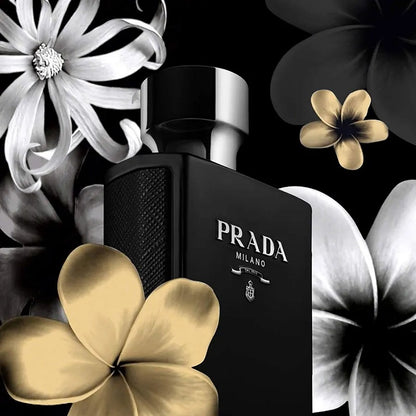 Prada Milano perfume bottle surrounded by flowers on a black background