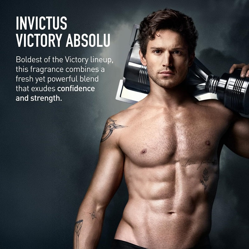 Man holding a perfume bottle with 'Invictus Victory Absolu' text on a dark background