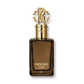 A bottle of Roberto Cavalli Uomo eau de parfum with a distinctive design, featuring a dark tint and a golden cap with an ornate logo.