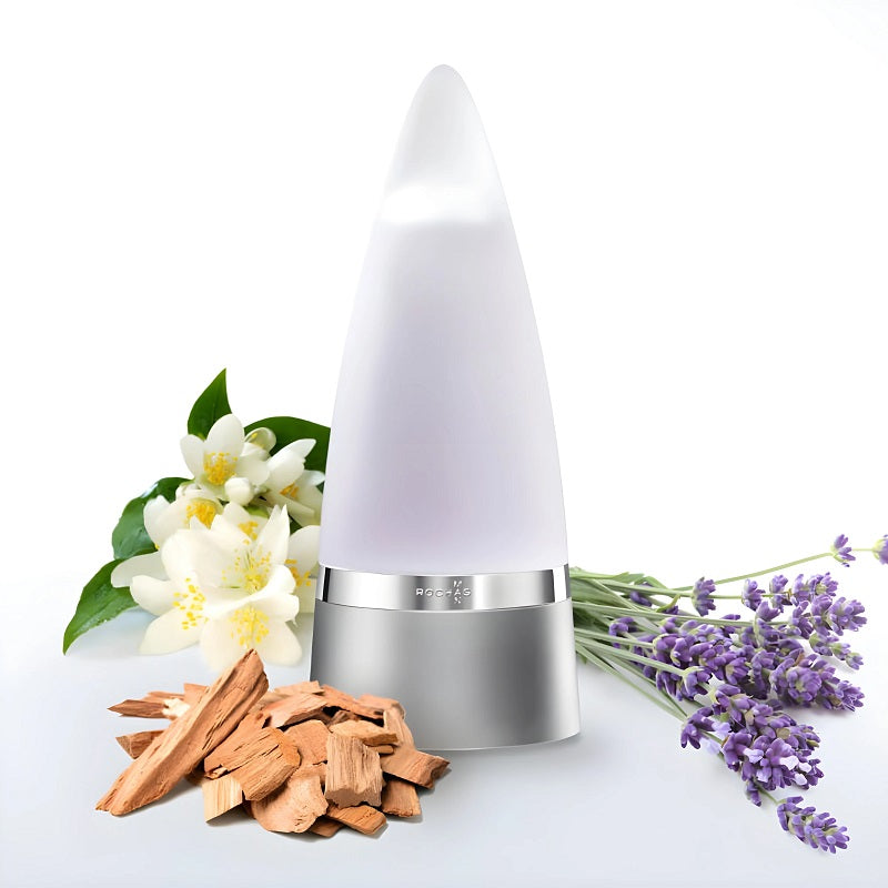 White diffuser with wooden chips, white flowers, and lavender on a light gray background