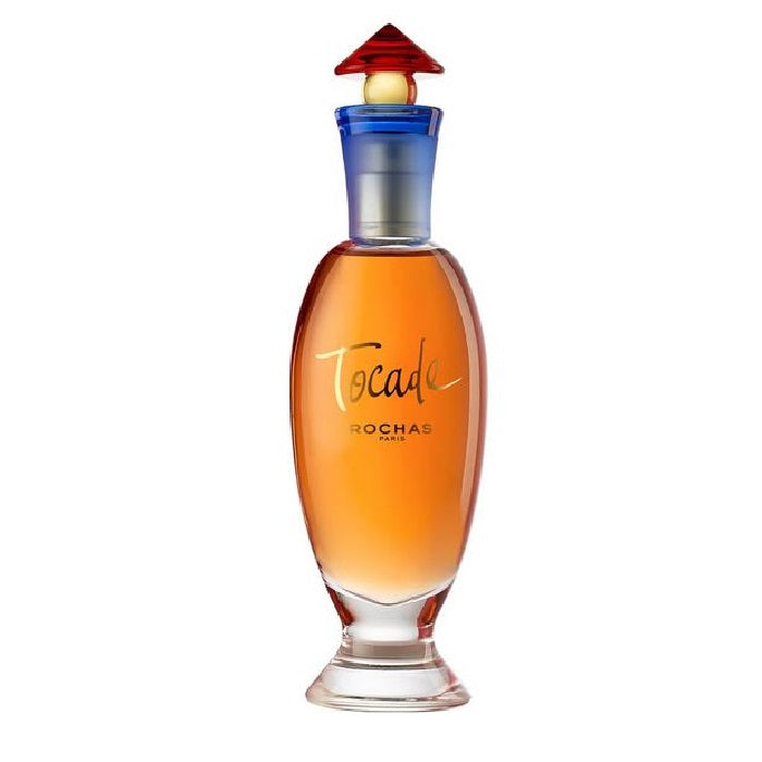 A bottle of Rochas Tocade Eau de Toilette with a clear liquid visible and a red cap on top.
