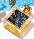 Perfume bottle with 'Roja' branding by a poolside