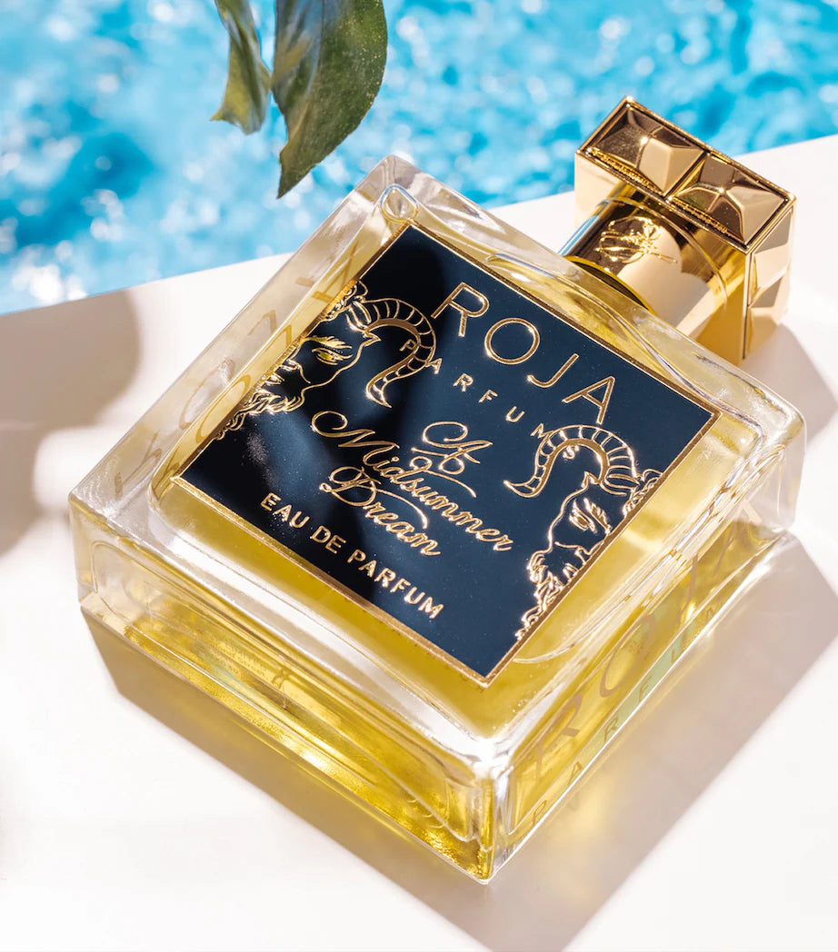 Perfume bottle with 'Roja' branding by a poolside