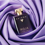 ROJA Parfums Enigma perfume bottle on purple fabric