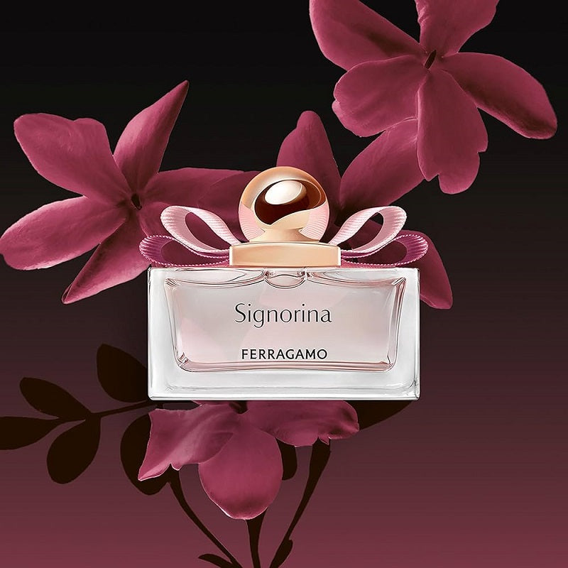 Ferragamo Signorina perfume bottle with pink flowers on a dark background