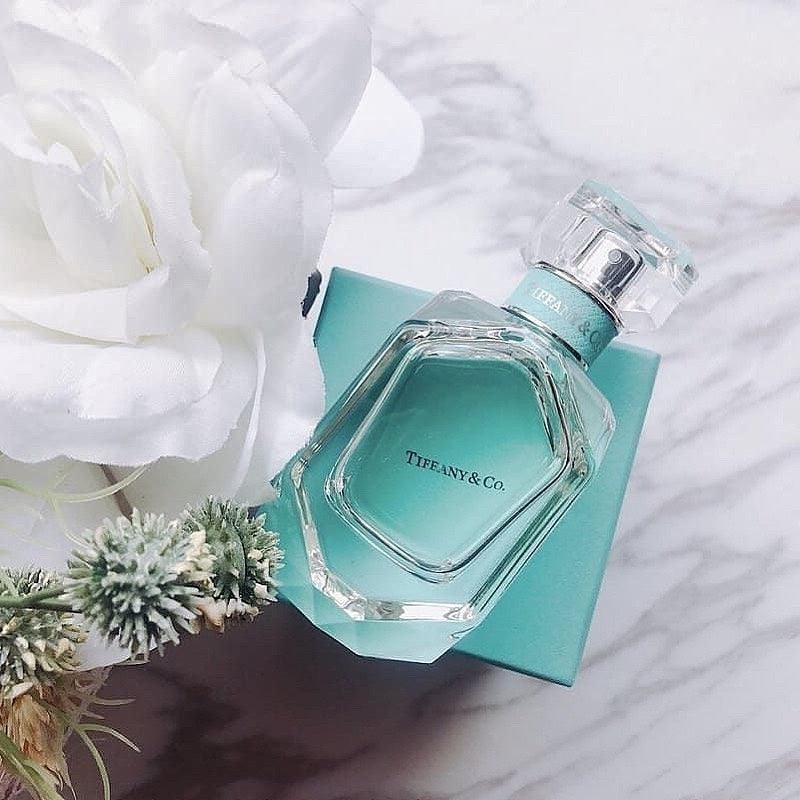 Tiffany & Co. perfume bottle on a matching box with white flowers in the background