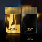 Two Tom Ford Noir Extreme parfum bottles, one gold and one black, on a dark background.