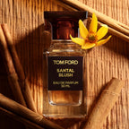 bottle of 50ml Santal Blush surrounded by ingredients against a bamboo background