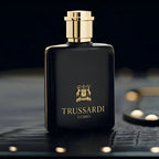 Trussardi perfume bottle on a dark textured surface with a blurred background