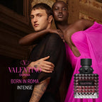 Two people embracing with a Valentino perfume bottle in the foreground.