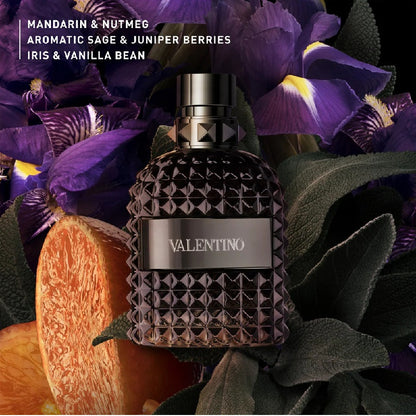 Valentino perfume bottle with purple flowers and orange fruit in the background