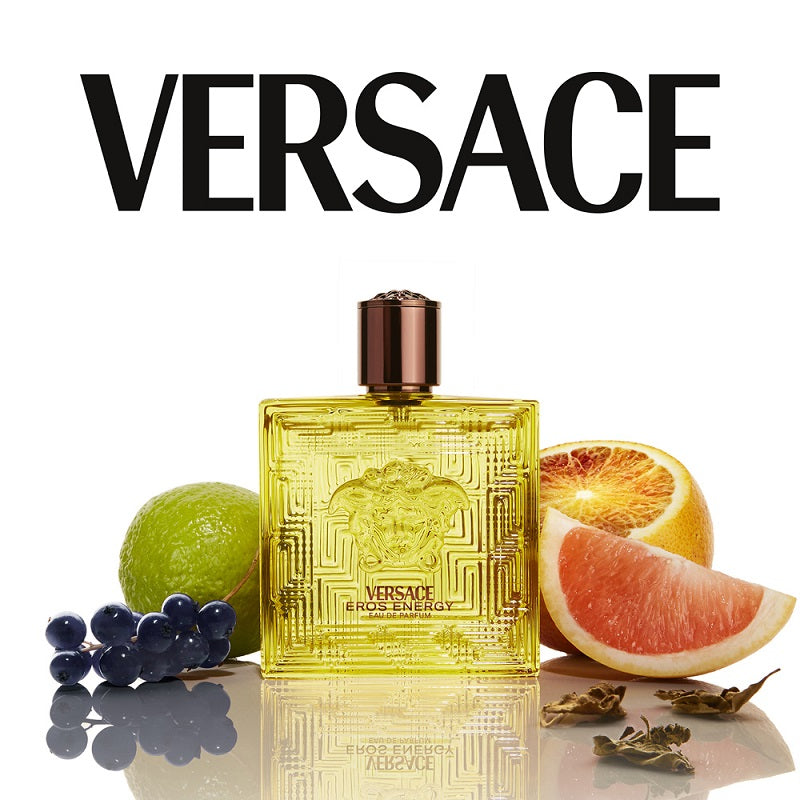 Versace Eros Energy perfume bottle with fruit slices on a white background
