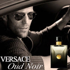 Man driving a car with a bottle of Versace Oud Noir perfume next to him.